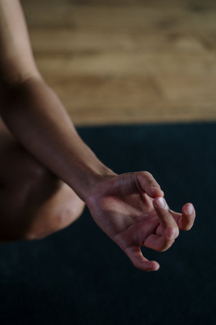 A close-up view of a hand in a yoga mudra position, symbolizing relaxation and focus.